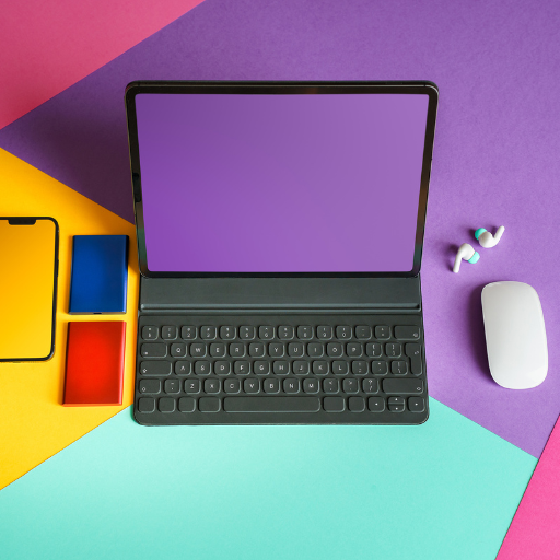 a laptop and phone on colored desk